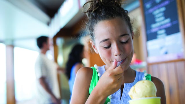 Liten tjej äter stor glass ombord på NCL:s fartyg.
