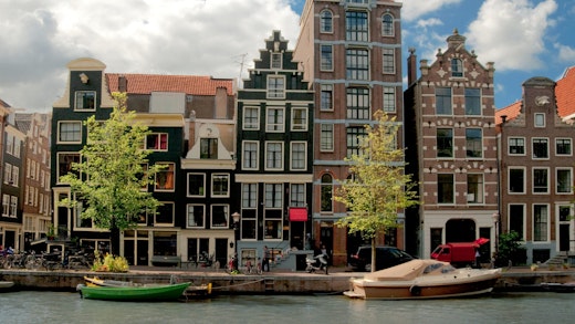 Vackra byggnader längs en kanal i Amsterdam, Nederländerna.