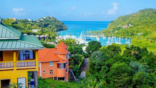 Färgglada hus, grön växtlighet och blått hav på St. Lucia.
