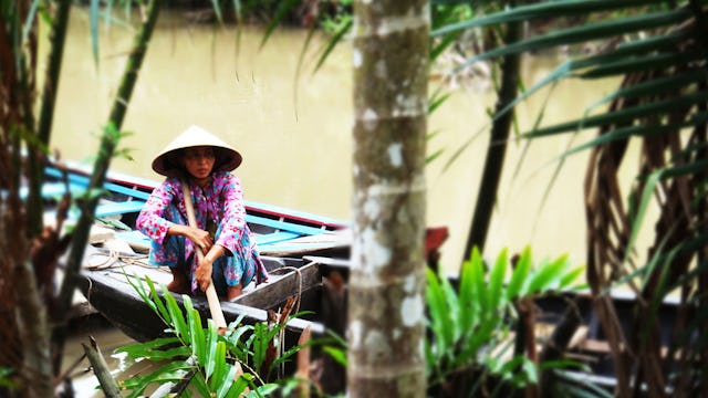 Kvinna i båt på Mekongfloden.
