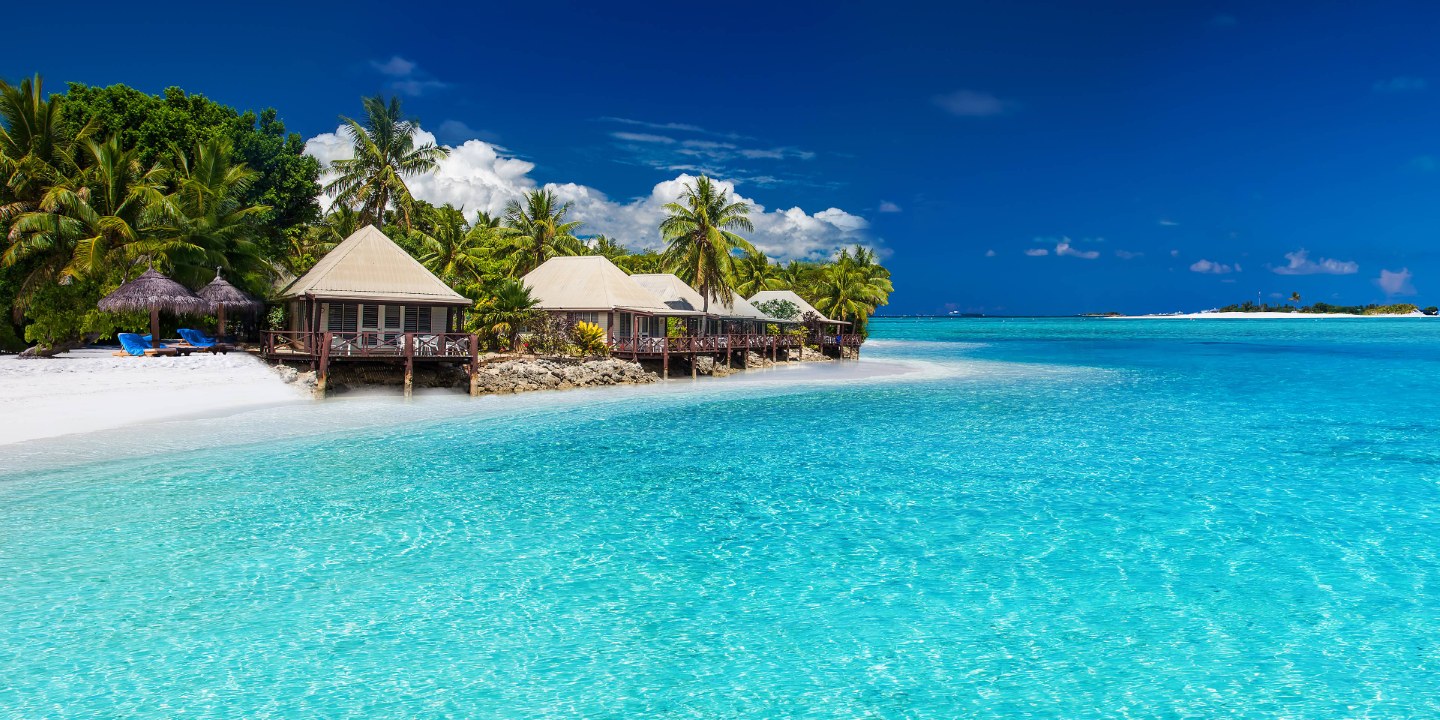 Vit sand och kristallklart ljusblått vatten