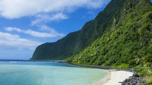 Vacker strand med grönskande kullar