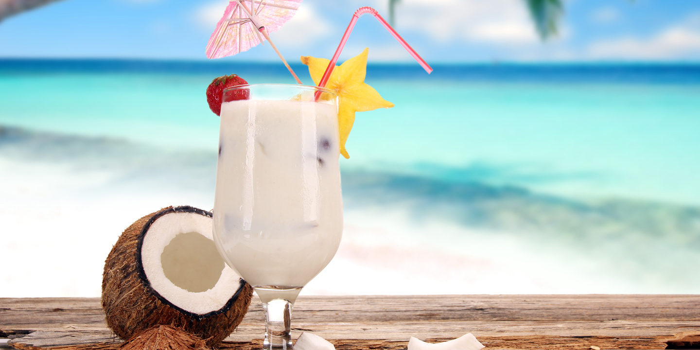 Romdrink med karibisk strand i bakgrunden.
