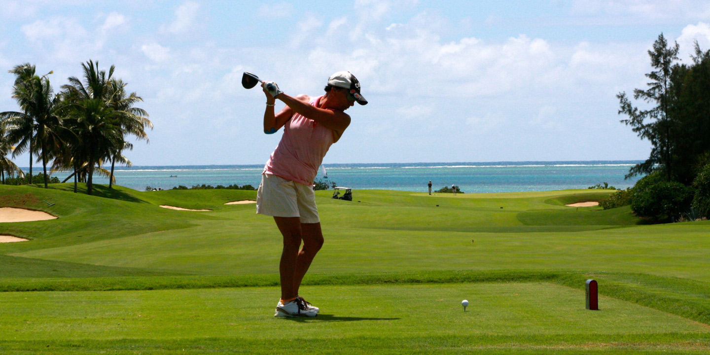 Kvinna ska precis slå ut golfbollen från tee.