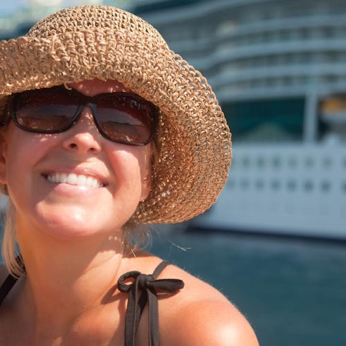 Glad kvinna framför ett kryssningsfartyg.